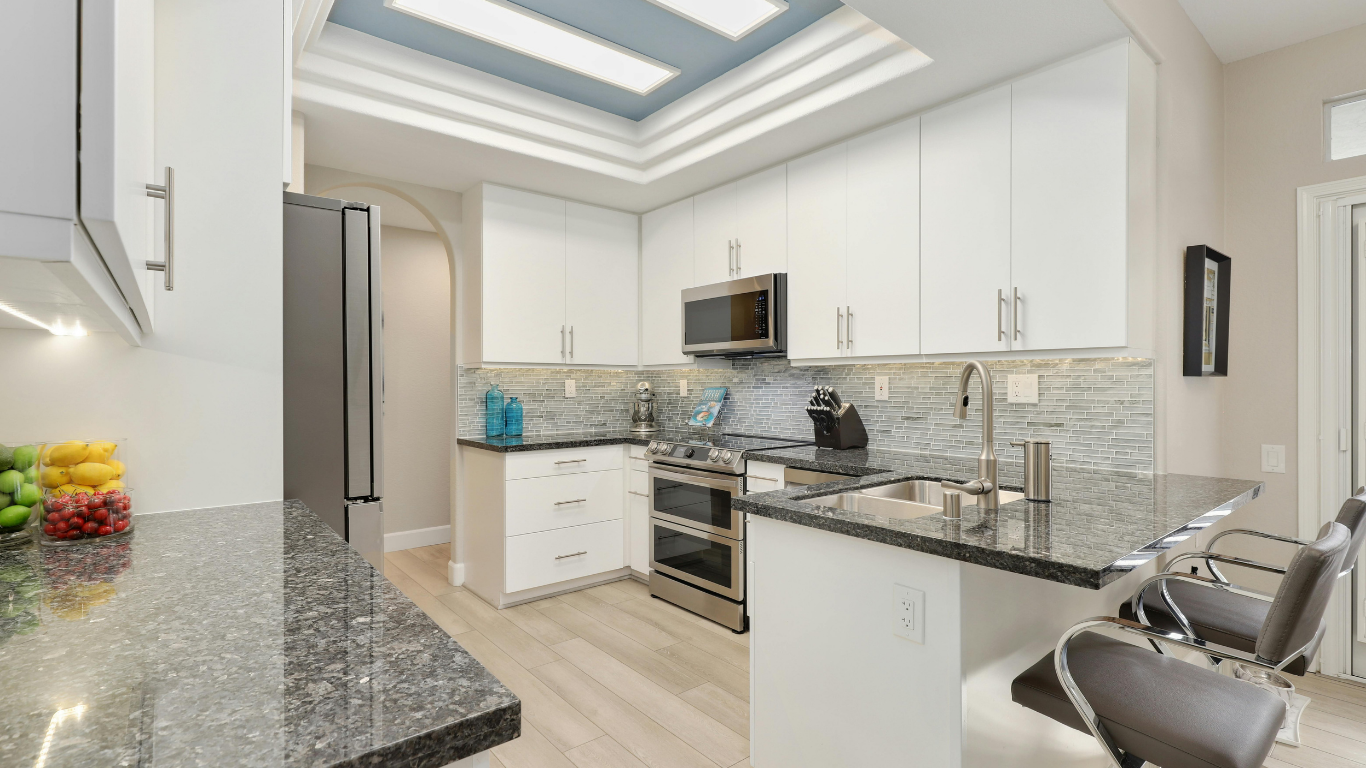 Modern white kitchen with skylights and stainless steel appliances after a deep clean